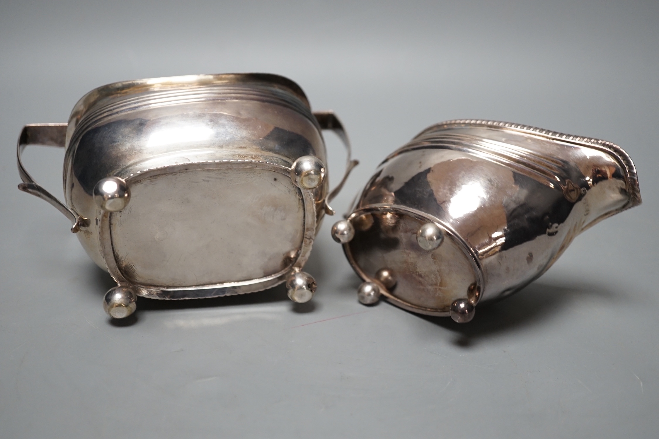 A George III silver cream jug, London, 1809 and a Georgian silver sugar bowl (marks rubbed), 11oz.